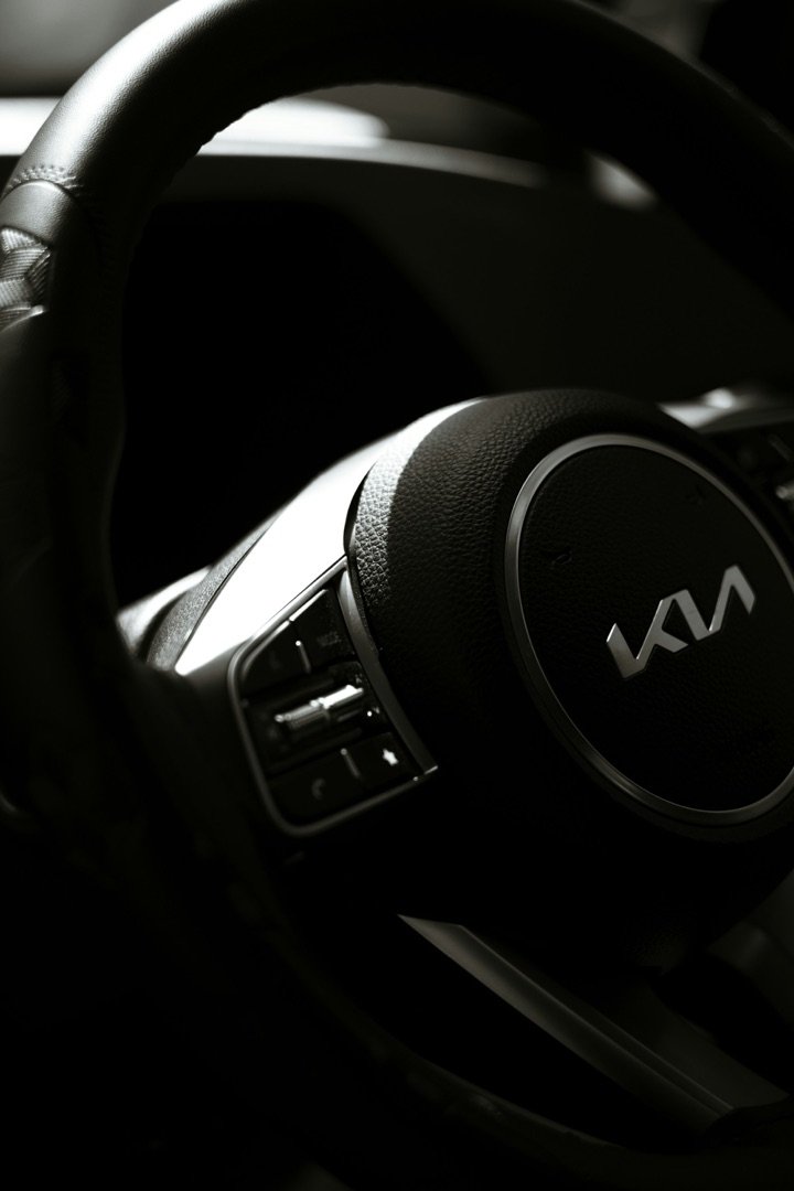 Close-up van een Kia-stuur in een donker auto-interieur